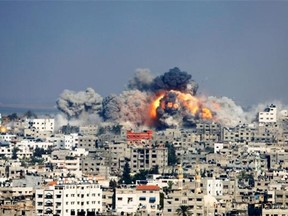 In this file photo taken Tuesday, July 29, 2014, smoke and fire from the explosion of an Israeli strike rise over Gaza City. In the grisly math of the Israel-Hamas war, conflicting counts of combatants and civilians killed in Gaza are emerging — with the ratio perhaps more important to shaping international opinion of the monthlong conflict than any final toll. UN researchers and local rights groups say three-fourth of some 1,900 dead were civilians, while the Israeli military estimates the split is closer to 50-50. Those doing the tallies use different methods and standards to make that all important determination of who is a civilian.