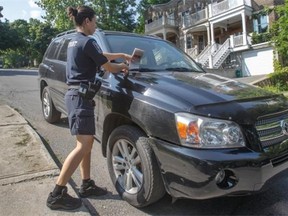 Westmount Public Safety agent Sabrina Tremblay tickets an illegally parked car on Clarke Ave. on Monday. The crackdown on drivers who don’t turn their wheels toward the curb comes after four recent incidents involving improperly parked vehicles rolling downhill.