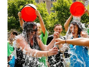 Two women get doused during the ice bucket challenge at Boston’s Copley Square to raise funds and awareness for ALS. The idea is easy: Take a bucket of ice water, dump it over your head, video it and post it on social media. Then challenge your friends, strangers, even celebrities to do the same within 24 hours or pay up for charity.
