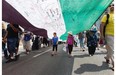 Two young girls walk under a 100 meter long Palestinian flag as they join a march to protest the living conditions in Gaza and the ongoing conflict with Israel. The group marched throughout the streets of Montreal on Sunday Aug. 10, 2014.