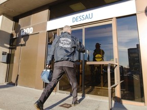 An agent from the Competition Bureau enters a building that houses the offices of Dessau, an engineering company, in Laval on Tuesday, November 6, 2012. The firm was one of four targeted by UPAC, the anti-corruption arm of the SQ.