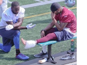 Alouettes cornerback Geoff Tisdale, right, holds back his pain, while applying ice to his ankle, while S.J. Green looks on. Tisdale hurt his ankle during Alouettes practice on Thursday Sept. 04, 2014.