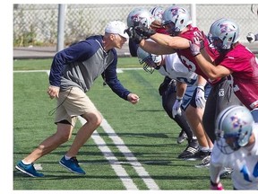 Alouettes head coach Tom Higgins, left, confronts the Alouettes offensive line, during practice in St-Léonard on Wednesday, Sept. 24, 2014.