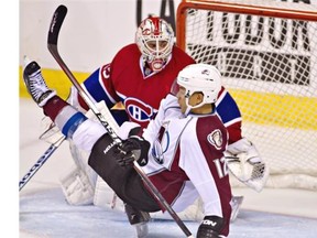 Avalanche forward Jarome Iginla takes a tumble in fornt of Canadiens’ Dustin Tokarski during first period of exhibition at Le Colisée in Quebec City on Friday night. Clément Allard/THE CANADIAN PRESS