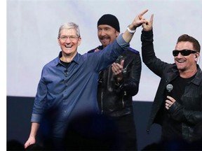 U2’s Bono, right, and the Edge, centre, rock out with Apple CEO Tim Cook at the company’s product launch on Sept. 9, which doubled as the launch for the Irish group’s new album, Songs of Innocence. Juan Rodriguez says U2 and Apple’s association is representative of that old trick: aligning a product with power, and vice versa.