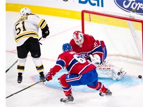 Bruins centre Ryan Spooner scores the first goal on Habs goalie Dustin Tokarski as defenseman Greg Pateryn looks on during first-period pre-season National Hockey League action Tuesday, Sept. 23, 2014. in Montreal.