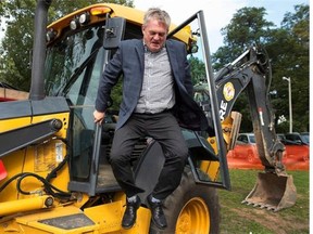 New Brunswick Progressive Conservative Premier David Alward jumps from a backhoe as he campaigns in Shediac, N.B on Saturday, Sept. 20, 2014. The provincial election is on Monday.