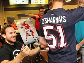 Canadiens’ David Desharnais interacts with fans and signs autographs as part of launch of new EA Sports NHL 15 video game on Tuesday in Montreal.
