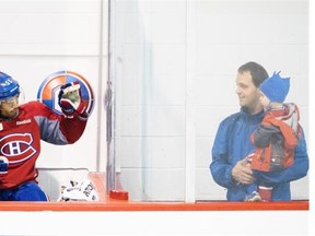Canadiens defenceman Francis Bouillon, left, waves at a spectator’s young son during training camp at the Bell Sports Complex in Brossard on Sunday.