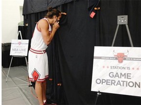 Chicago Bulls center Joakim Noah peeks in on a teammate's photo session during the Bulls' NBA basketball media day, Monday, Sept. 29, 2014, in Chicago.