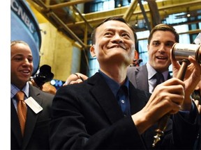 Chinese online retail giant Alibaba founder Jack Ma (C) holds up a gravel before ringing a bell to open trading on the floor at the New York Stock Exchange in New York on September 19, 2014. A buying frenzy sent Alibaba shares sharply higher Friday as the Chinese online giant made its historic Wall Street trading debut.