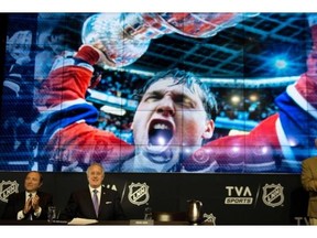 NHL commissioner Gary Bettman, left to right, chairman of the board at Quebecor Inc. Brian Mulroney, and former Canadien Yvan Cournoyer watch a presentation at the launch of the NHL season on TVA Sports network Wednesday in Boucherville.