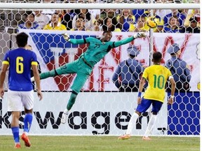 Ecuador goalkeeper Alexander Dominguez, center, makes a save on a shot by Brazil as Neymar (10) attacks during the second half of an international soccer friendly match, Tuesday, Sept. 9, 2014, in East Rutherford, N.J. Ecuador's Cristhian Noboa is at left.