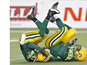 Edmonton Eskimos Odell Willis (41) and Gregory Alexandre (95) celebrate a sack against the Saskatchewan Roughriders during first half action in Edmonton, Alta., on Friday September 26, 2014.