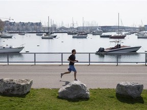 A jogger runs along the waterfront area near Toronto's Ontario Place on Monday May 19, 2014.