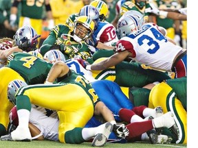 Eskimos’ Pat White is pushed in for the first down against the Alouettes during first-half action in Edmonton, Alta., on Friday September 12, 2014.