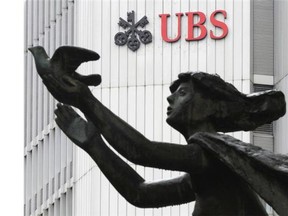 FILE — In this March 19, 2012 file photo the logo of the Swiss bank UBS is pictured behind a statue in Zurich, Switzerland. UBS AG agreed Wednesday, Dec. 19, 2012 to pay some US$1.5 billion in fines to international regulators following a probe into the rigging of a key global interest rate. In admitting to fraud, Switzerland’s largest bank became the second bank, after Britain’s Barclays PLC, to settle over the rate-rigging scandal. The fine, which will be paid to authorities in the U.S., Britain and Switzerland, also comes just over a week after HSBC PLC agreed to pay nearly US$2 billion for alleged money laundering. (AP Photo/Keystone, Steffen Schmidt) ORG XMIT: ZUR252
