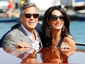 George Clooney, left, and Amal Alamuddin arrive in Venice, Italy, Friday, Sept. 26, 2014. Clooney, 53, and Alamuddin, 36, are expected to get married this weekend in Venice, one of the worldís most romantic settings.