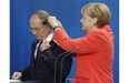 German Chancellor Angela Merkel, right, adjusts the translator headphone of the President of Myanmar, Thein Sein, during a joint press conference as part of a meeting at the chancellery in Berlin, Germany, Wednesday, Sept. 3, 2014.