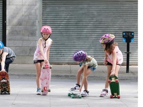 A group of kids get ready to skateboard down some stairs as they take part in skateboarding lesson from Samuel Kardash, not seen, at Peace Park in Montreal on Sunday August 10, 2014.