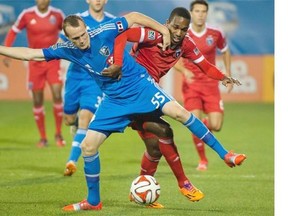 Impact’s Wandrille Lefevre, left, and San Jose Earthquakes’ Atiba Harris battle for the ball during first half MLS soccer action in Montreal on Saturday.