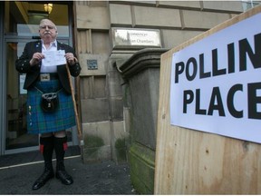 James Fraser holds up his voting card having just voted at Lothian Chambers polling station in central Edinburgh on September 18, 2014, in Edinburgh, Scotland. After many months of campaigning the people of Scotland today head to the polls to decide the fate of their country. The referendum is too close to call but a Yes vote would see the break-up of the United Kingdom and Scotland would stand as an independent country for the first time since the formation of the Union.