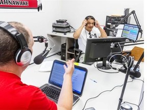 K103’s news director, Paul Graif, in red, and morning host Lance Delisle chat during a break in Studio A in Kahnawake.