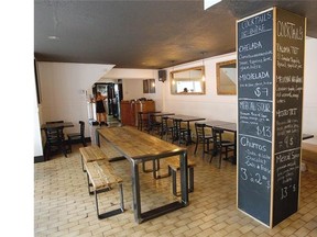 The main dining area at T&T Tacos & Tortas features rustic seating and a column of chalkboard specials.
