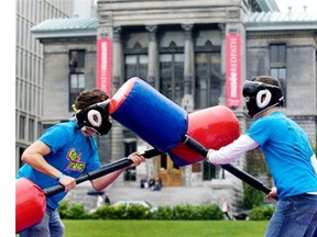 Two management students try to knock each other from their pillar as they take part in games as part of Frosh week activities at McGill University.