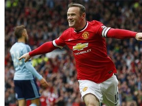 Manchester United’s English striker Wayne Rooney celebrates scoring the opening goal during the English Premier League football match between Manchester United and West Ham United at Old Trafford in Manchester on Saturday, September 27, 2014.
