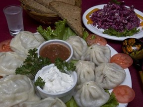 Manty dumplings (left) and Hinkali dumplings (right) with sour cream and a tomato sauce, rye bread, beets and nuts salad and a shot of Stolichnaya vodka at Restaurant La Caverne in Montreal.