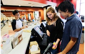 Miranda Rafuse and William Chin scan items for customer Steve Visitacion at Jake’s Café at Vanier College in the St-Laurent area of Montreal Wednesday, September 10, 2014. Vanier is the first CEGEP in the province to ban both fried foods and soft drinks. It is also launched Jake’s Café, the new co-op cafeteria  to be run by students, all in an effort to promote healthier eating.