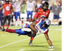 Montreal Alouettes S.J. Green completes a pass as Ottawa Redblacks Eddie Elder(5)looks on during CFL football action between the Ottawa Redblacks and the Montreal Alouettes in Ottawa, Friday September 26, 2014.