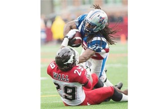 Montreal Alouettes’ James Rodgers is pulled down by Calgary Stampeders’ Jamar Wall during during the second half at Molson Stadium in Montreal on Sunday, Sept. 21, 2014.