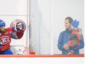 Montreal Canadiens defenseman Francis Bouillon, left, waves at Victor and his two year old son Maxime during the team's training camp at the Bell Sports Complex in Brossard, south of Montreal on Sunday, September 21, 2014.