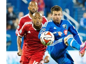 Montreal Impact’s Jack McInerney, right, and San Jose Earthquakes’ Pablo Pintos battle for the ball in Montreal, Sept. 20, 2014.