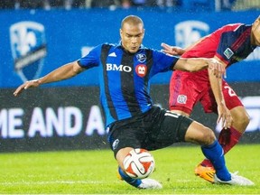 Montreal Impact’s Matteo Ferrari, left, and Chicago Fire’s Quincy Amarikwa battle for the ball during second half MLS soccer action in Montreal, Saturday, August 16, 2014.