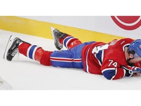 Montreal Canadiens defenceman Alexie Emelin lies on the ice after being checked head-first into the boards by Colorado Avalanche Maxime Talbot during National Hockey League pre-season game in Montreal Thursday September 25, 2014.  Talbot was penalized on the play.