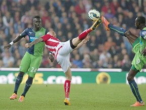 Newcastle United's Senegalese striker Papiss Cisse (R) challenges Stoke City's Irish midfielder Stephen Ireland (C) during the English Premier League football match between Stoke City and Newcastle United at the Britannia Stadium in Stoke-on-Trent, north-west England, on September 29, 2014.