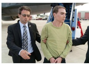 Luka Magnotta is taken by police from a military plane to a waiting van in Mirabel on June 18, 2012.