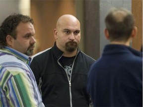 Desiderio Pompa, centre, a man known to act as a bodyguard for leaders in the Mafia, waits outside a Montreal courtroom for his sentencing hearing on Friday, September 26, 2014.