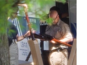 Police officers catalogue guns outside the home of Isidore Havis, the armed 71-year-old man involved in a 20-hour police standoff in 2013, in the Cote-St-Luc area of Montreal.