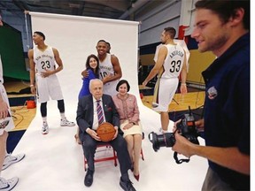 New Orleans Pelicans Eric Gordon (10) hugs team co-owner Rita Benson LeBlanc as they set up for a group photo with owner Tom Benson, seated, and his wife Gayle Benson, at the Pelicans NBA basketball media day in Metairie, La., Monday, Sept. 29, 2014. At left are Pelicans Omer Aski, Anthony Davis (23) and at right are Ryan Anderson (33) and NBA photographer Layne Murdoch, Jr.