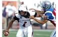Ottawa Redblacks quarterback Henry Burris tries to fight off  Montreal Alouettes defender Chip Cox  in the first half of a pre-season CFL game at Molson stadium in  Montreal, on Friday, June 19, 2014.