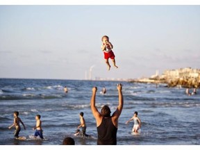 A Palestinian man plays with his baby on a beach on September 7, 2014 in Gaza city.