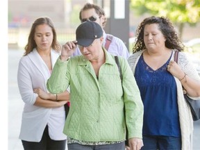 Pamela Porter, centre, wife of Dr. Arthur Porter, arrives at SQ headquarters with family in Montreal, Wednesday, September 3, 2014.  She turned herself into police before Crown prosecutors began proceedings to revoke her bail.  (Phil Carpenter / THE GAZETTE)