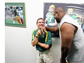 Patrick Kabongo give a gentle forearm to Dwayne Mandrusiak as he shows players the equipment room after the official opening of the Edmonton Eskimos brand new dressing room in Commonwealth Stadium in Edmonton Alberta on Saturday July 3, 2010.