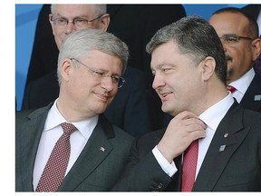Prime Minister Stephen Harper chats with Ukrainian President Petro Poroshenko during the the official family photo in Newport, Wales during the NATO Summit on Thursday September 4, 2014.