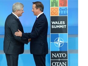Prime Minister Stephen Harper is greeted by British Prime Minister David Cameron in Newport, Wales at the NATO Summit on Thursday September 4, 2014.