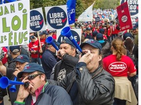 Protesters make noise as they gather near Lafontaine Park during a demonstration against pension reform proposed in Bill 3 in Montreal on Saturday.